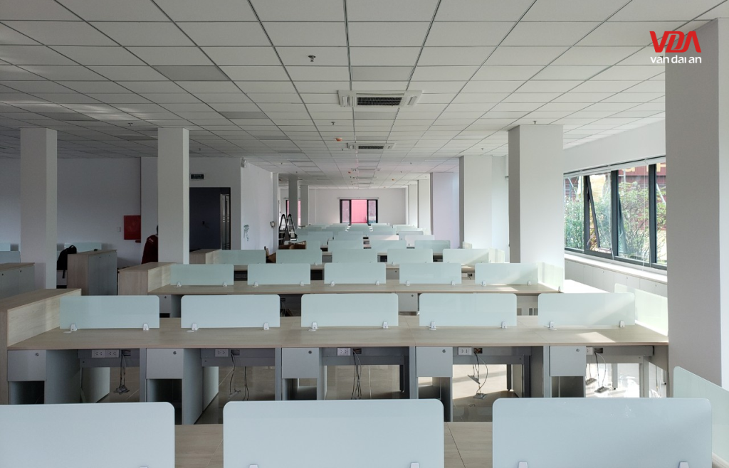 Không gian văn phòng làm việc thiết kế mở với hệ thống bàn module hiện đại và ánh sáng tiêu chuẩn